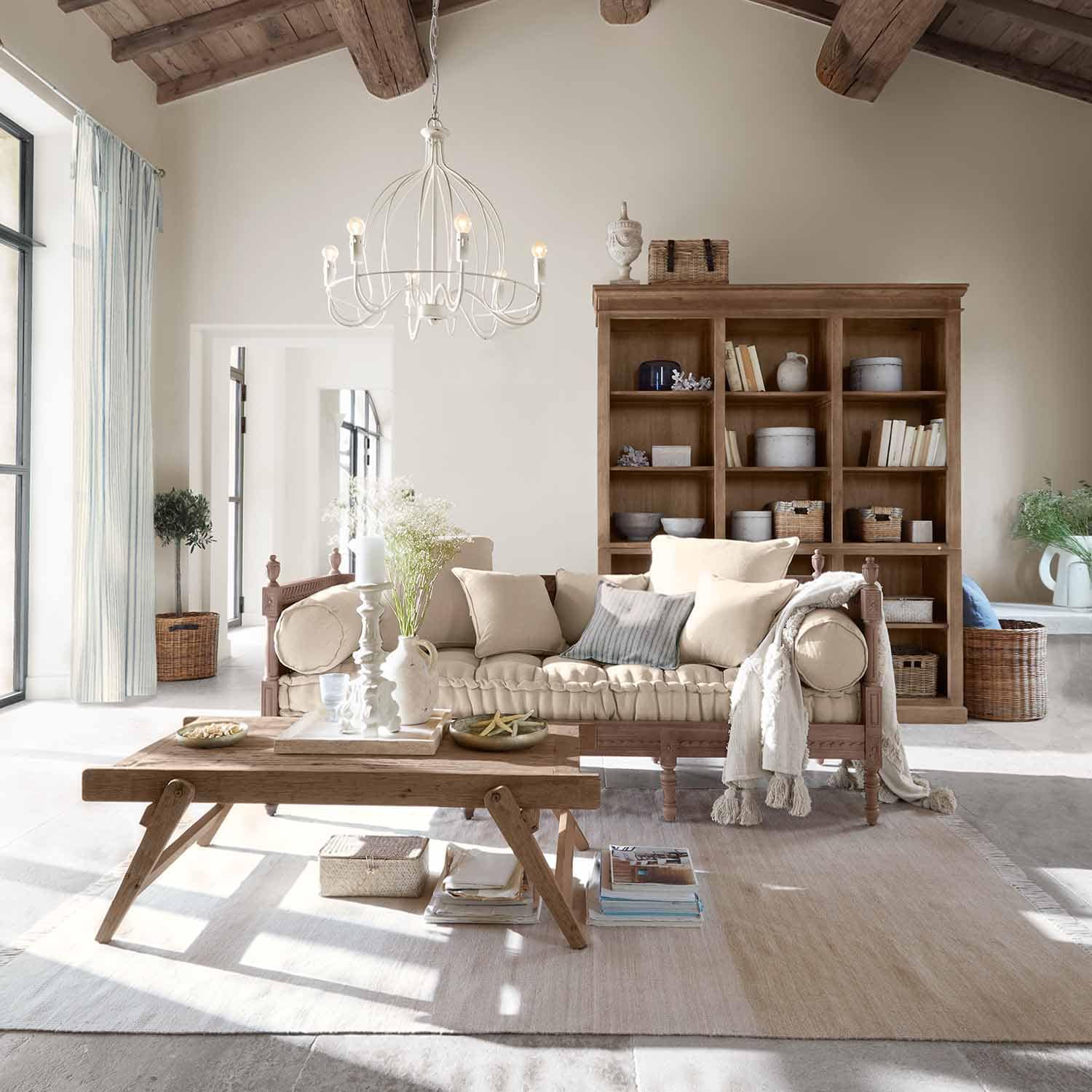 Pohodlný obývací pokoj s dřevěnou pohovkou a béžovými polštáři, rustikálním dřevěným konferenčním stolkem