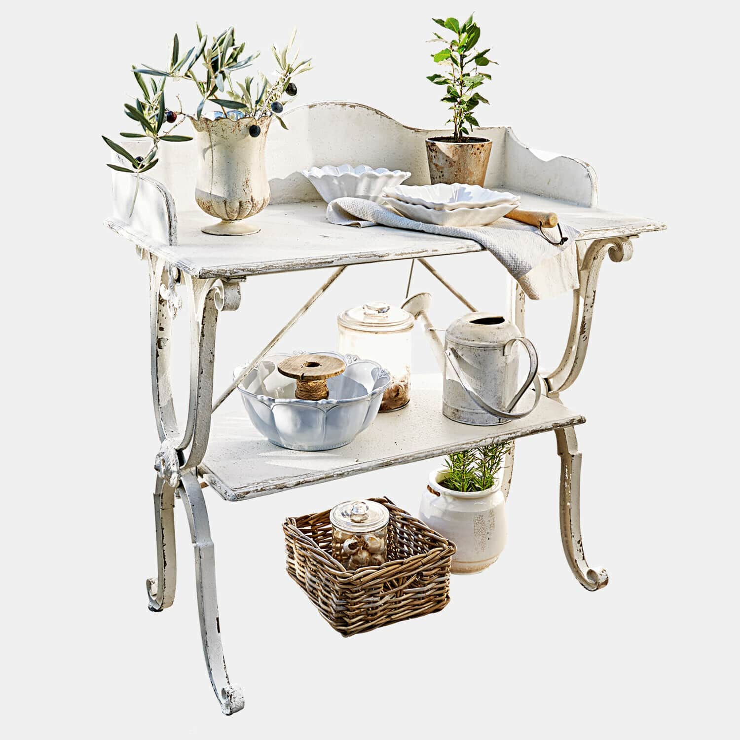 Bílý kovový zahradní stolek s dekorativním nádobím a rostlinami ve vintage stylu