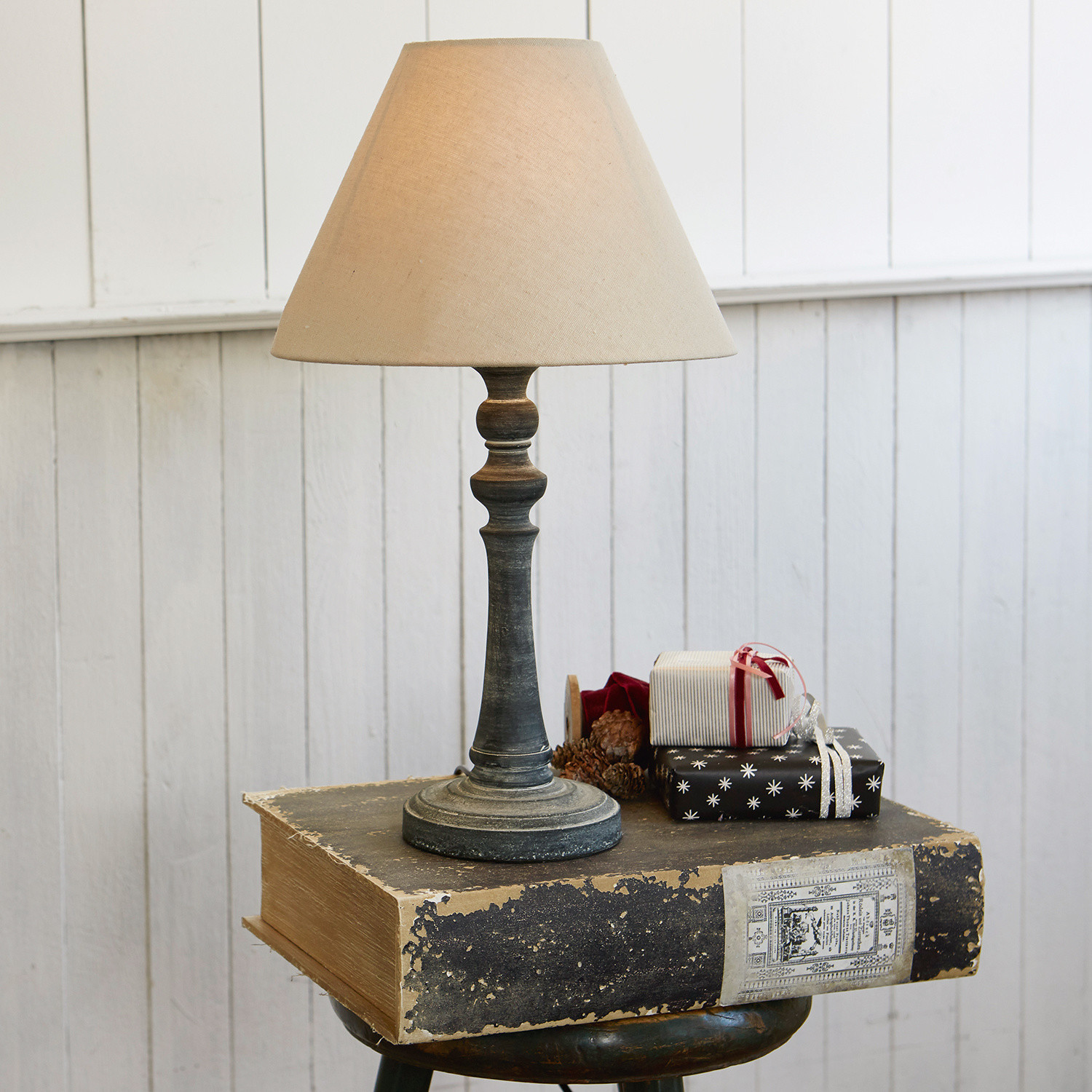 Stolní lampa Withby Stolní lampa s béžovým stínidlem a postaršeným černým podstavcem na bílém pozadí